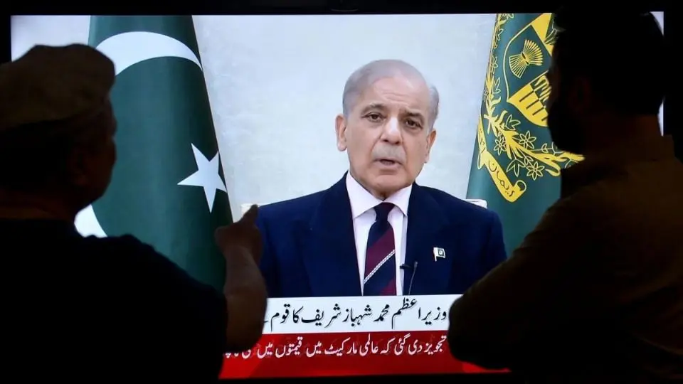 Televised political speech with Pakistani flags