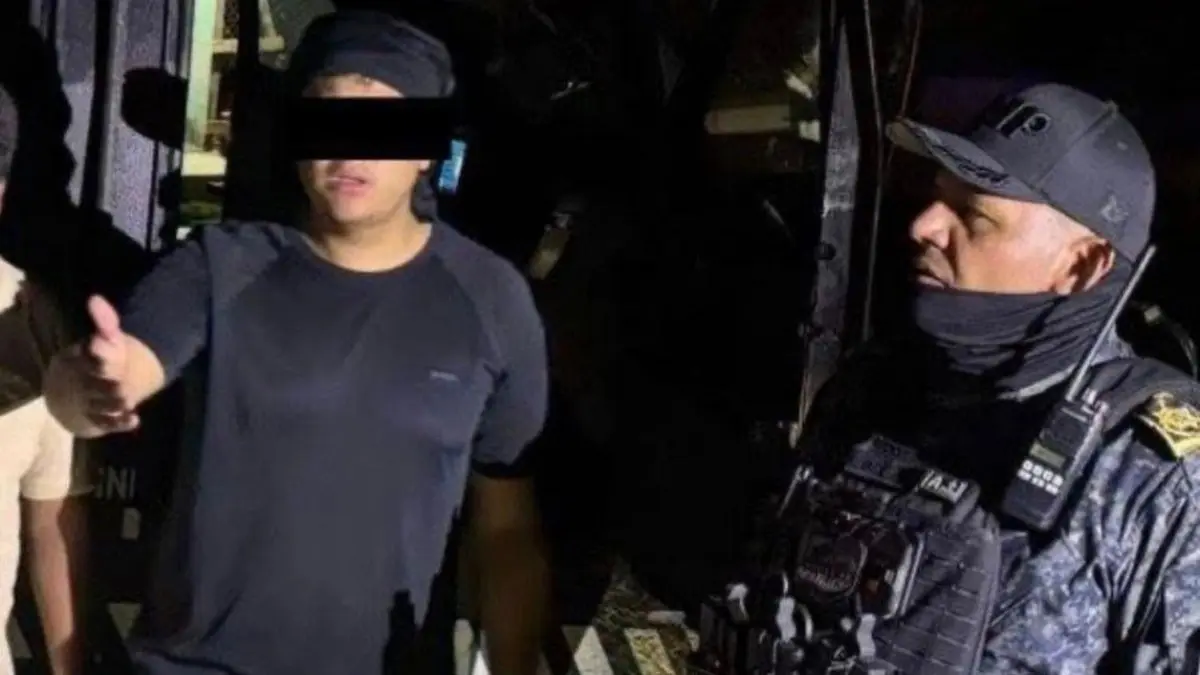 Uniformed officer speaking with man at night