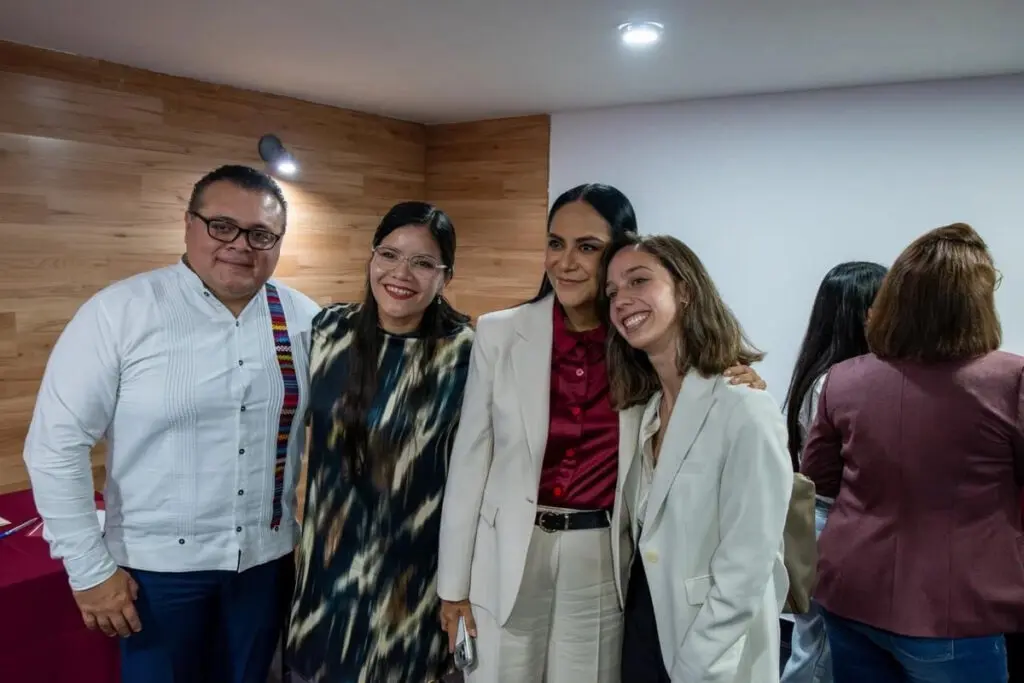 Four colleagues smiling together at indoor event