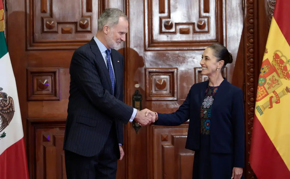 Officials shaking hands between Mexican and Spanish flags