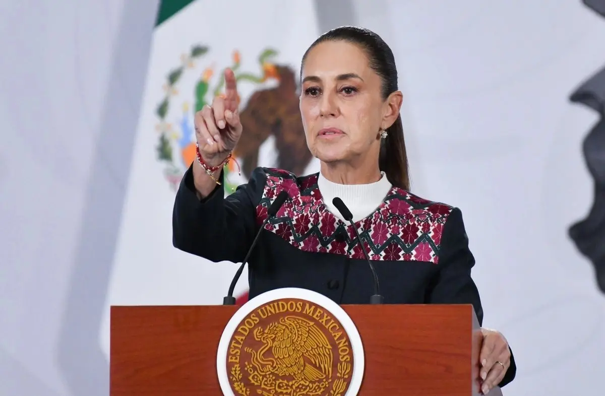 Woman politician speaking at podium with Mexican emblem