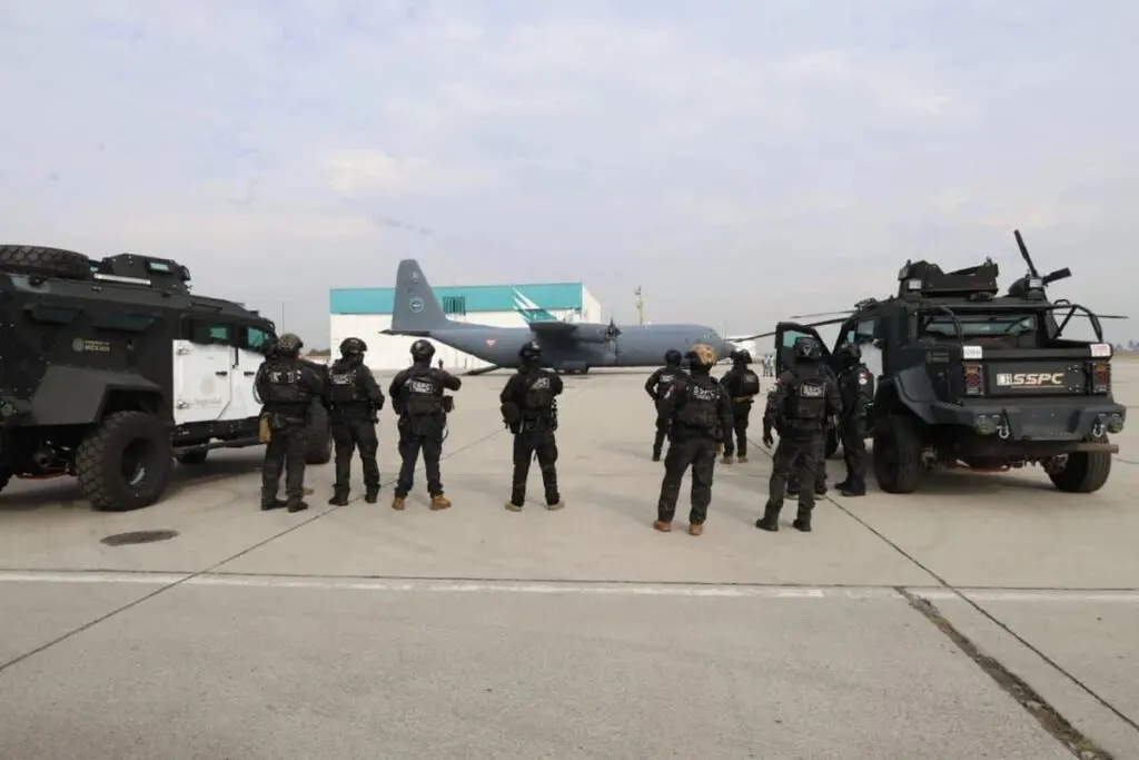 Tactical officers by armored vehicles near transport plane