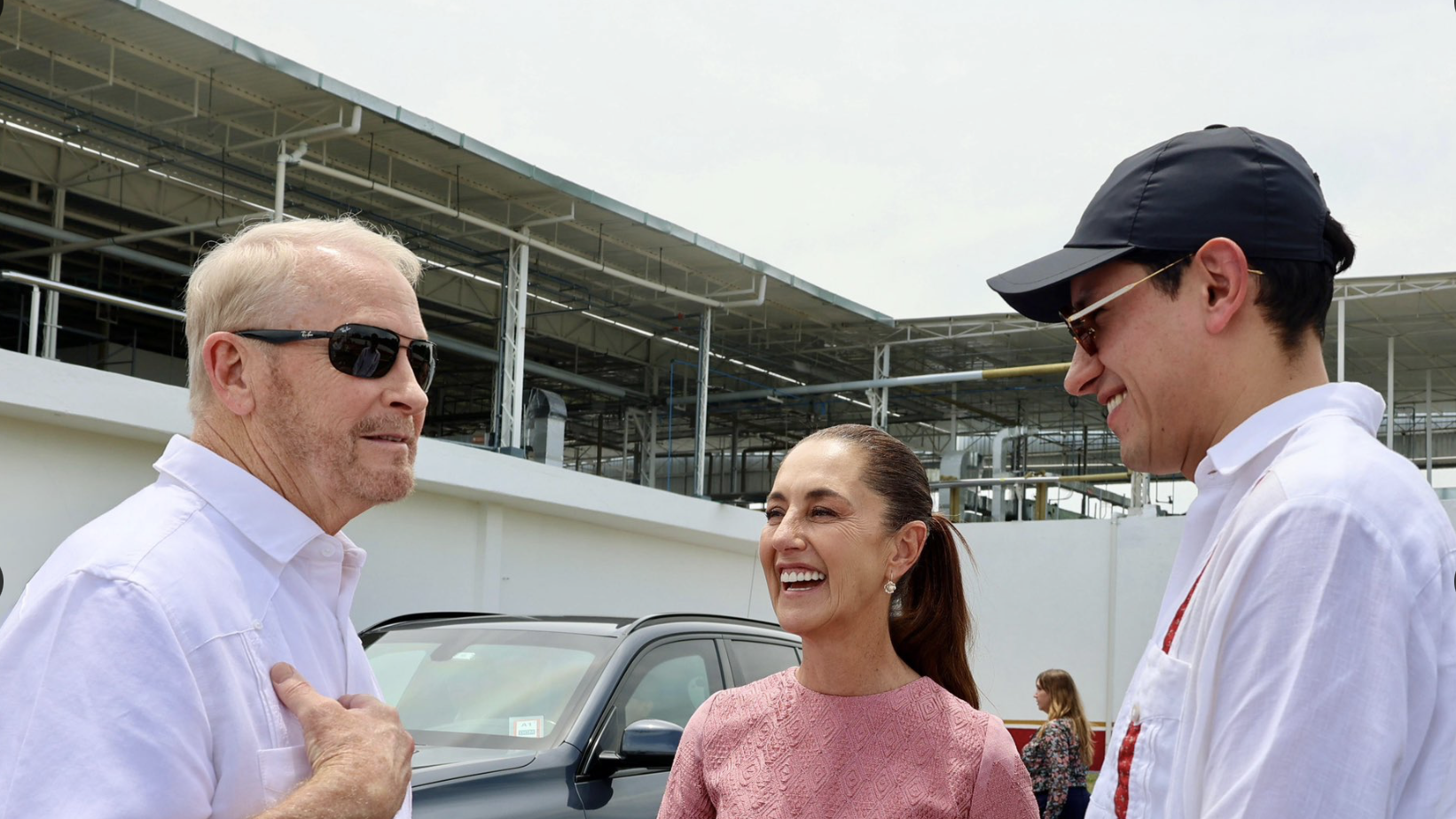Three people smiling and talking outdoors