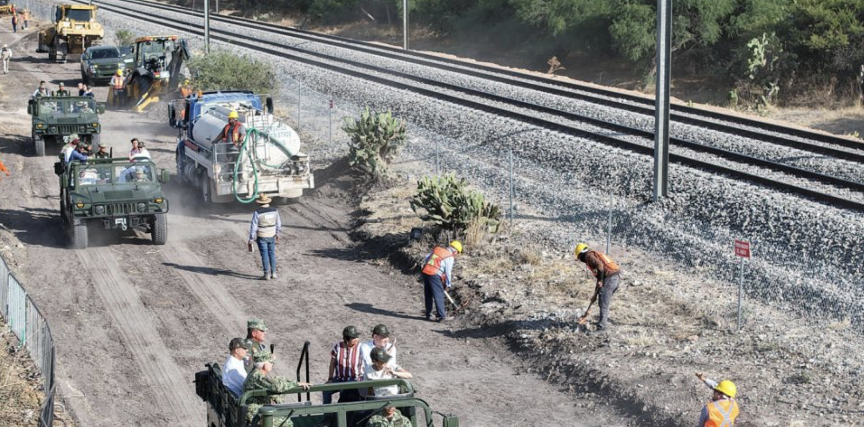 Workers and vehicles beside railroad tracks