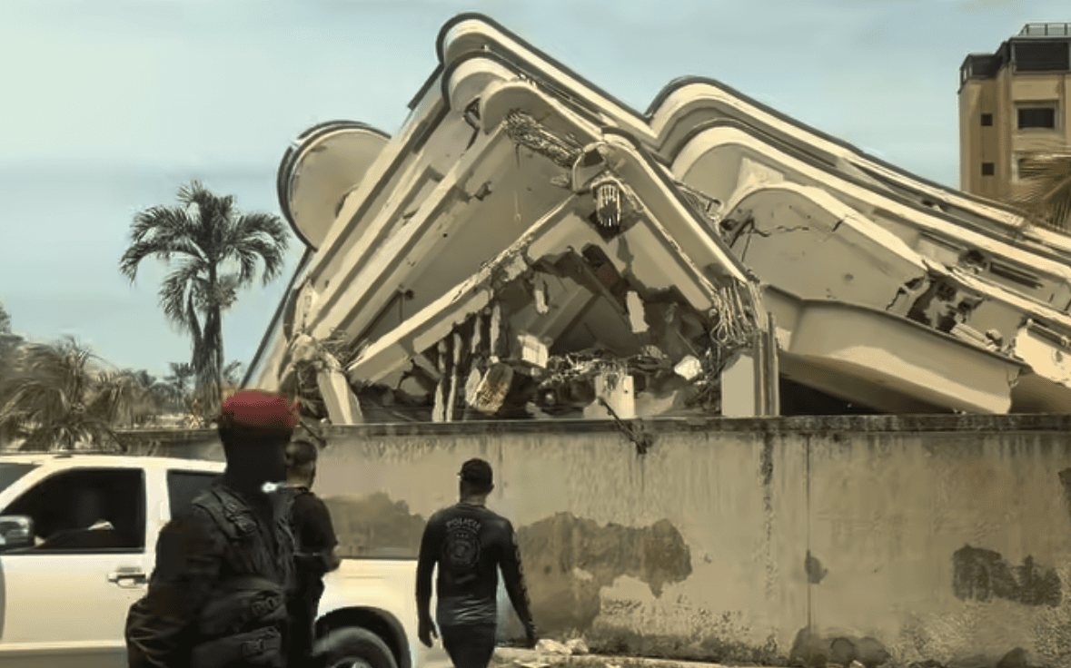 Edificio parcialmente colapsado tras sismo en Venezuela con presencia de policía y escombros visibles en zona urbana afectada