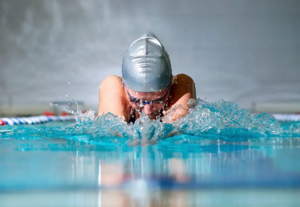 Imagen ilustrativa de una competencia de natación en estilo mariposa en piscina olímpica