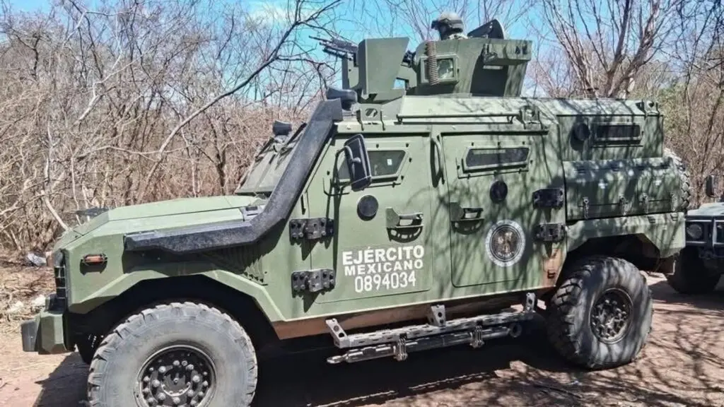 Military vehicle parked in a wooded area.