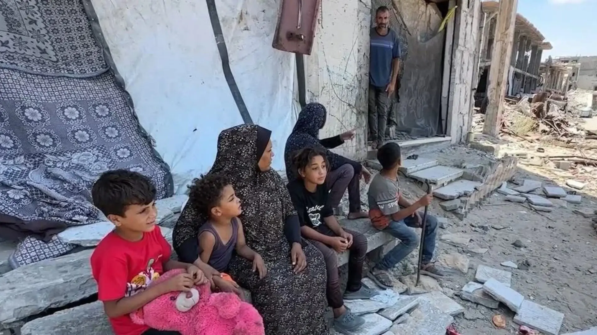 Niños palestinos entre los escombros de un edificio destruido en Gaza