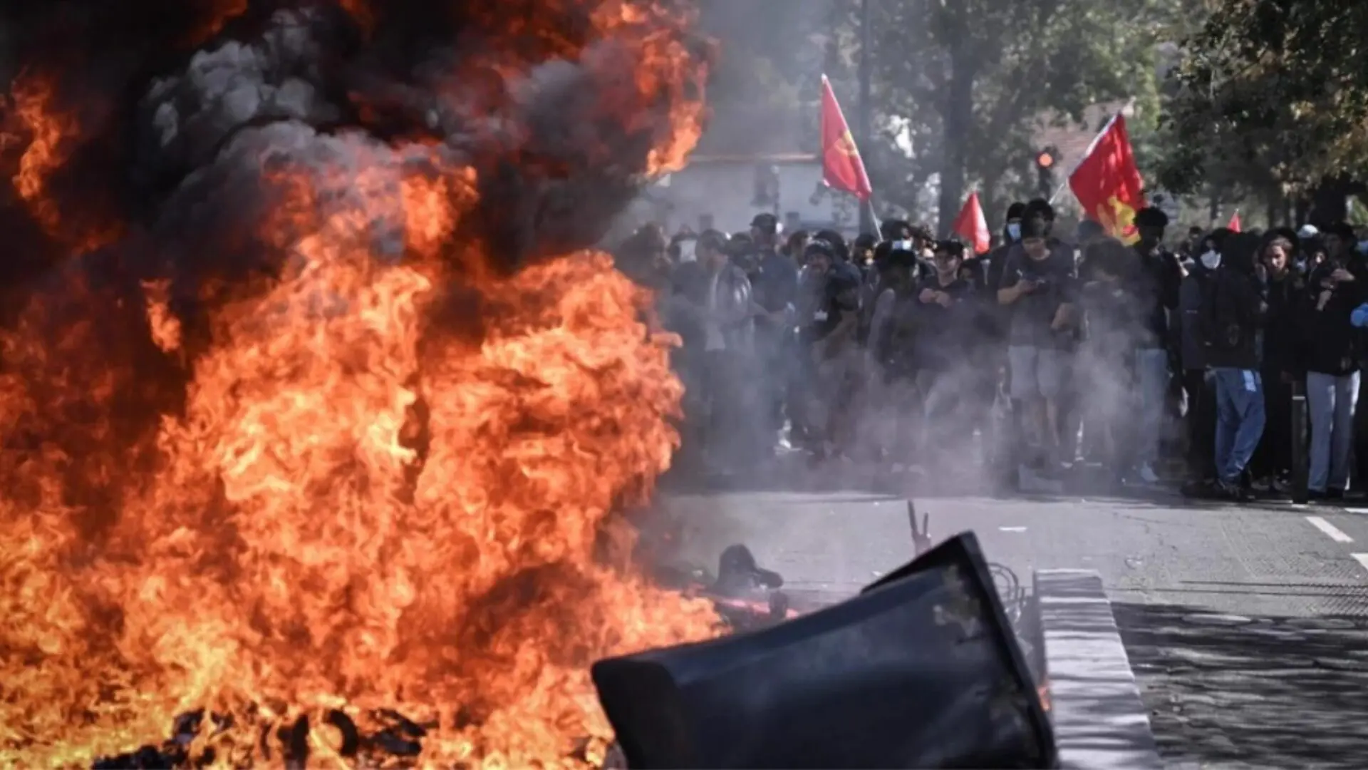 Manifestantes se concentran detrás de una barricada en llamas durante las protestas en Francia