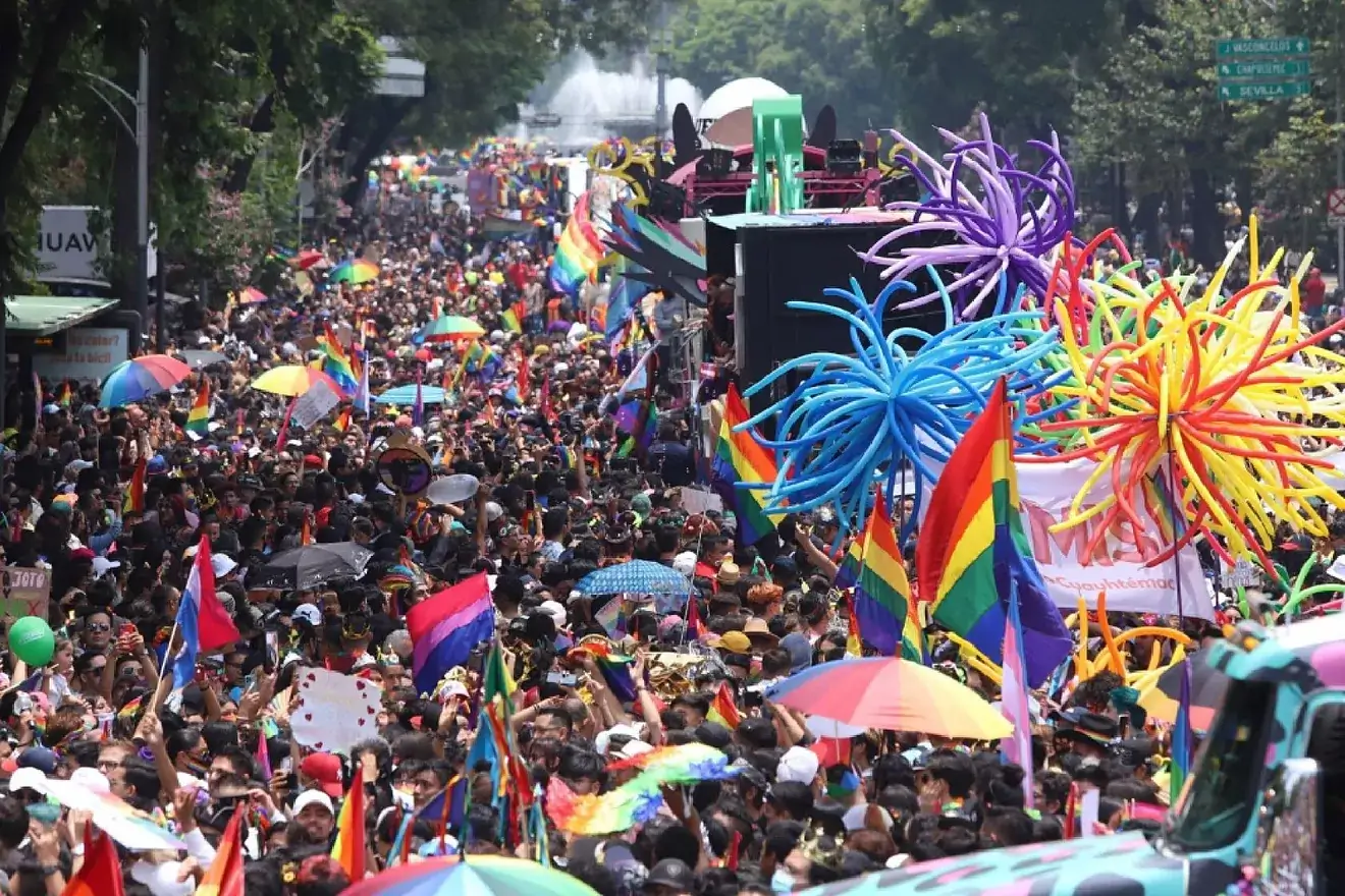 Colorful pride parade with rainbow flags, decorations.