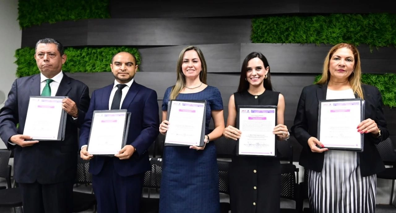 Five people holding certificates, smiling together.