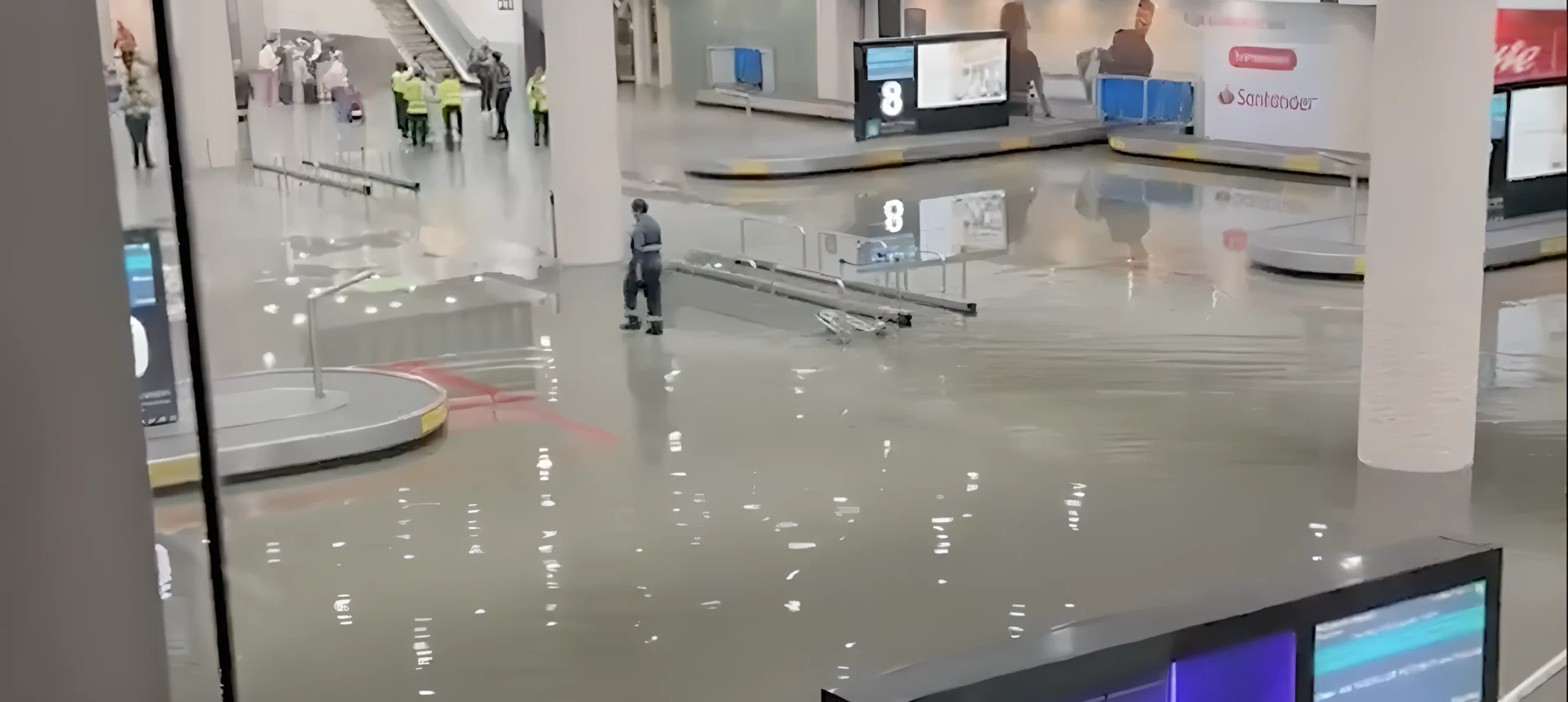 Flooded airport baggage carousel with passengers