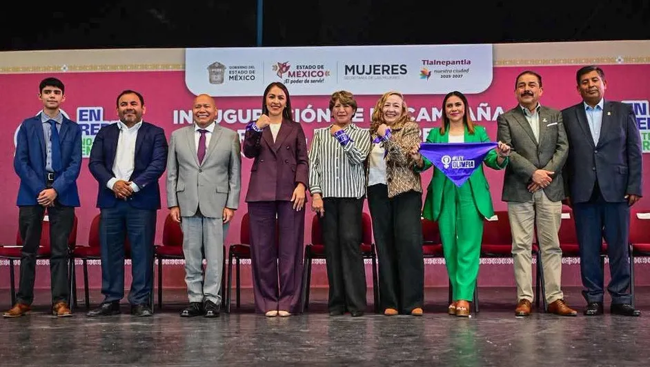 Group of people on stage holding banner.