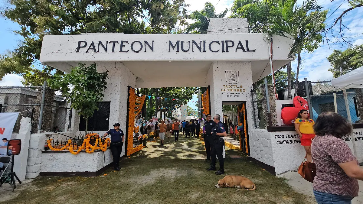 Entrada del Panteón Municipal de Tuxtla Gutiérrez decorada con flores de cempasúchil y presencia policial durante operativo en la colonia Maldonado