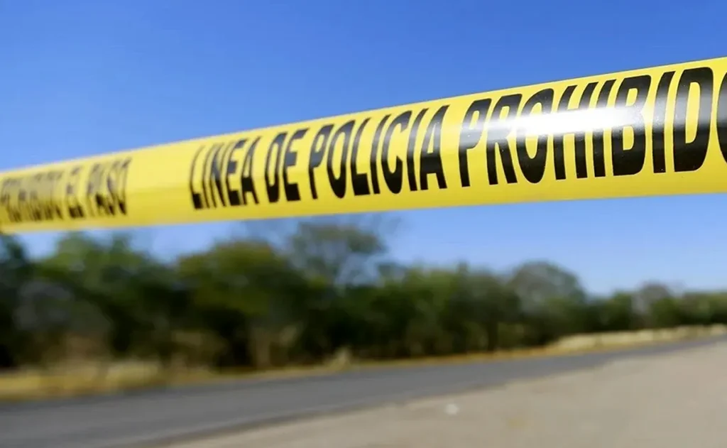 Cinta amarilla con la leyenda “Línea de policía prohibido el paso” colocada en una carretera tras el hallazgo de tres jóvenes calcinados en Chiapas.