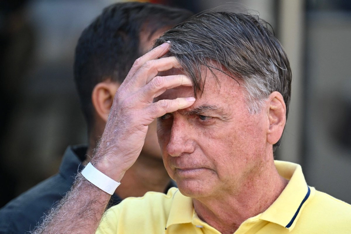 Jair Bolsonaro agarrándose el cabello, con medio rostro cubierto por su mano.